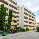 Aussenansicht des Gebaeudes mit Wohnungen und Fahrradstaender im Innenhof