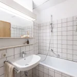 Modernes Badezimmer einer hochwertigen Wohnung im Stadtteil Lehel in München mit begehbarer Dusche und freistehender Badewanne