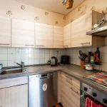 Kompakte Einbauküche mit hellen Holzfronten, Spüle und Elektrogeräten