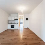 Hochwertige, weiße Einbauküche mit Kochinsel und Edelstahlgeräten in einer modernen Eigentumswohnung in München-Lehel