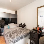 Modernes Schlafzimmer mit Doppelbett, großem Kleiderschrank und Schminktisch mit Spiegel