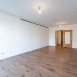 Modernes Wohnzimmer einer Luxuswohnung im Münchner Stadtteil Lehel nahe dem Englischen Garten, mit großen Fenstern und stilvoller Einrichtung