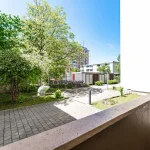 Ausblick von der Loggia auf den begrünten Innenhof mit Bäumen und Fahrradständern