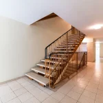 Heller Treppenhausbereich mit offener Treppe und Metallgeländer in einer Immobilie