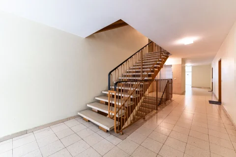 Heller Treppenhausbereich mit offener Treppe und Metallgeländer in einer Immobilie