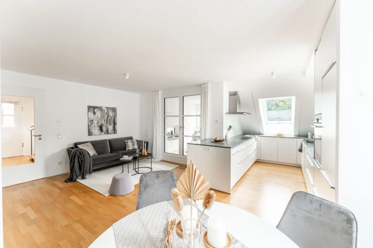 Helles Apartment kombiniert Wohnen und Essen: Sofa, Kunstwerke, Esstisch, moderne Küche mit Kochinsel. Geschmackvolles Interieur mit Holzboden, weiß begin a subtle yet refined aesthetic.