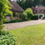 Eine grüne Zufahrt, gesäumt von Bäumen und Büschen, führt zu einem Grundstück in Diessen am Ammersee.